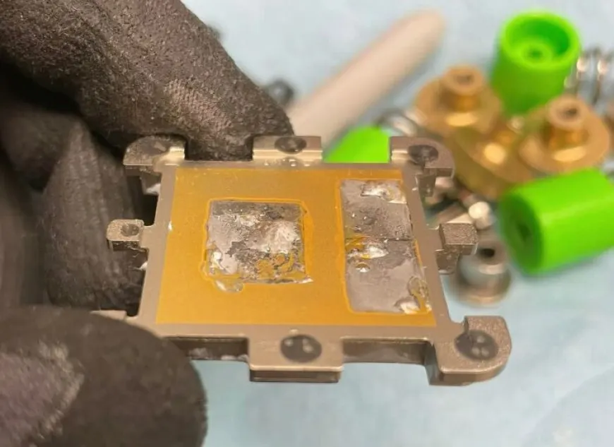 Delidded AMD Ryzen 7000 desktop CPU showing a gold-plated IHS and liquid TIM on the Zen 4 CCDs and I/O die.