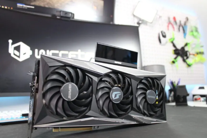 A Colorful iGame GeForce RTX 3090 Ti Vulcan-OC graphics card features quad-slot cooling and an LCD display panel.
