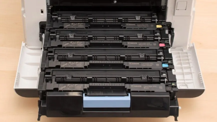 A Canon toner cartridge sits next to a printer screen that displays a warning message.