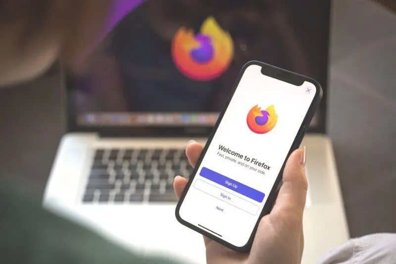 The Firefox 151 update interface displays cross-platform profile synchronization and PDF tools.