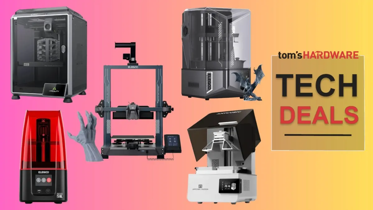 Several desktop 3D printers and filament spools are arranged on a display table.