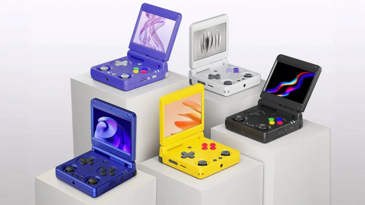 An Anbernic retro gaming handheld console resting on a surface with its screen turned on.