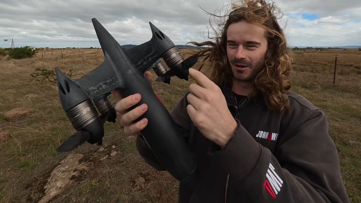 A custom drone features carbon fiber propellers with sawtooth leading edges during a controlled high-speed test.