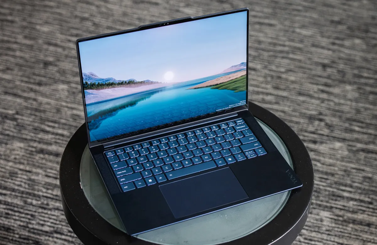 Multiple laptops rest on a study desk alongside open notebooks and a coffee cup.