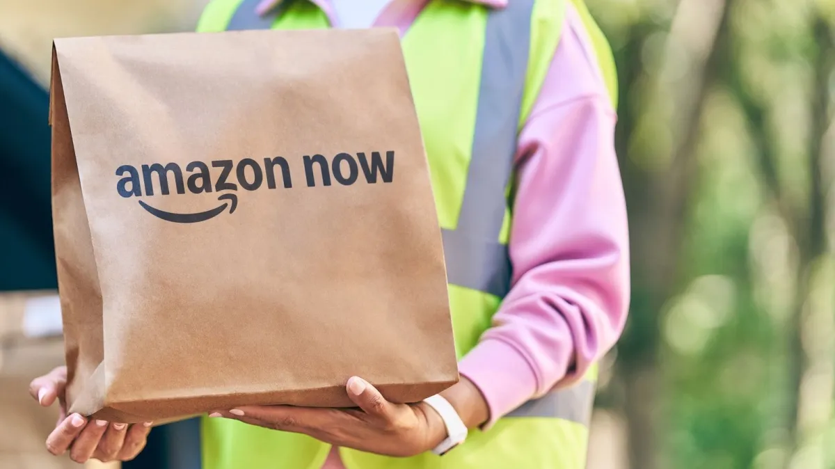 Amazon delivery vehicles depart a micro fulfillment center for thirty minute grocery service across US cities.
