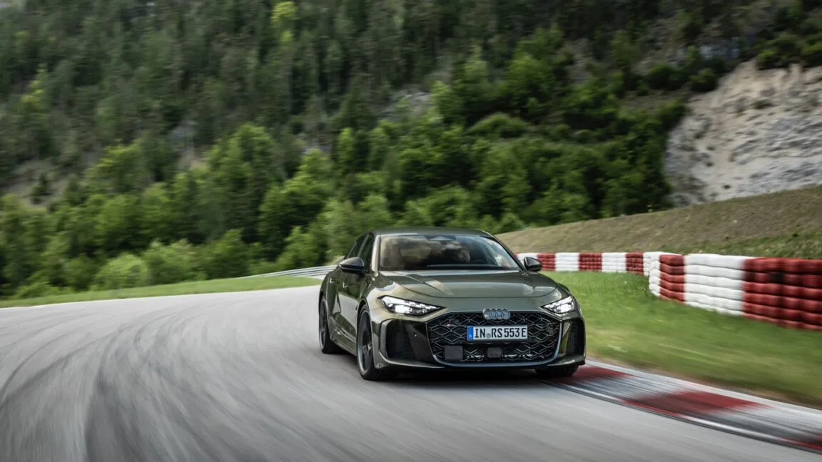 The 2027 Audi RS5 plug-in hybrid is shown from a front three-quarter angle on a paved road.