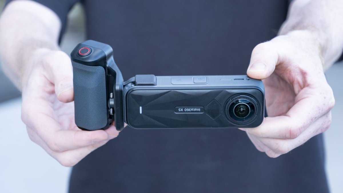 An action camera is fitted with a specialized grip accessory to improve handling during still photography.