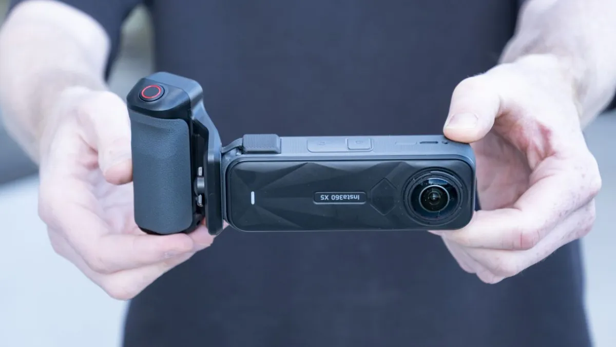An action camera is fitted with a specialized grip accessory to improve handling during still photography.