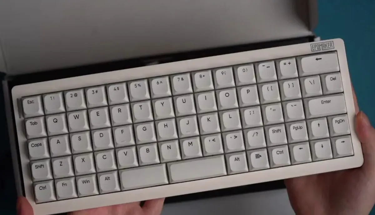 The photograph shows the Epomaker Hack70 ortholinear keyboard with its compact grid layout and key switches clearly visible.