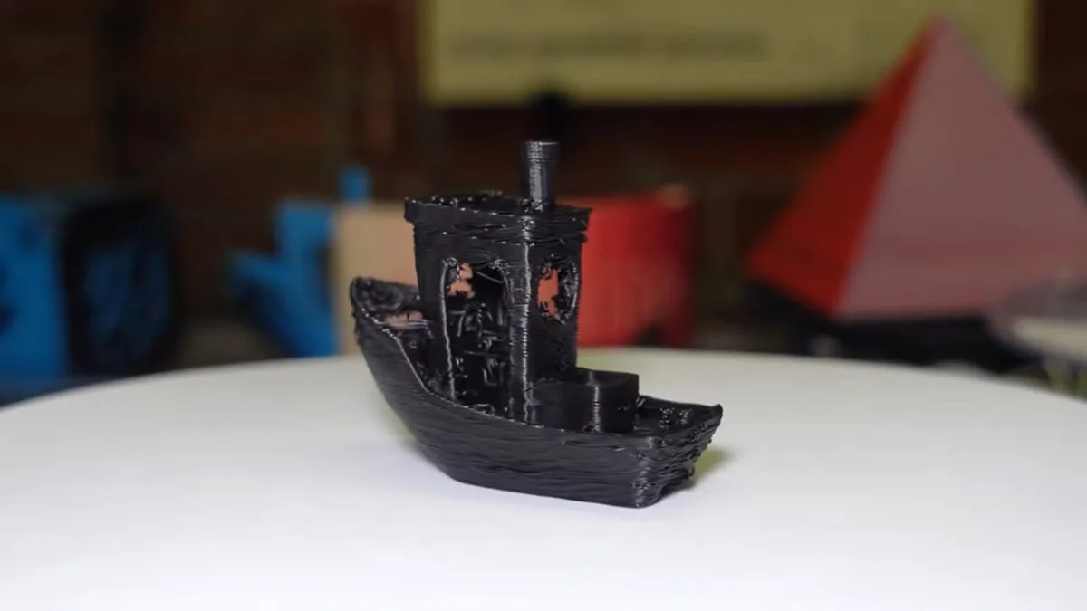 A custom Minuteman printer displays a 3DBenchy model completed in under sixty seconds.