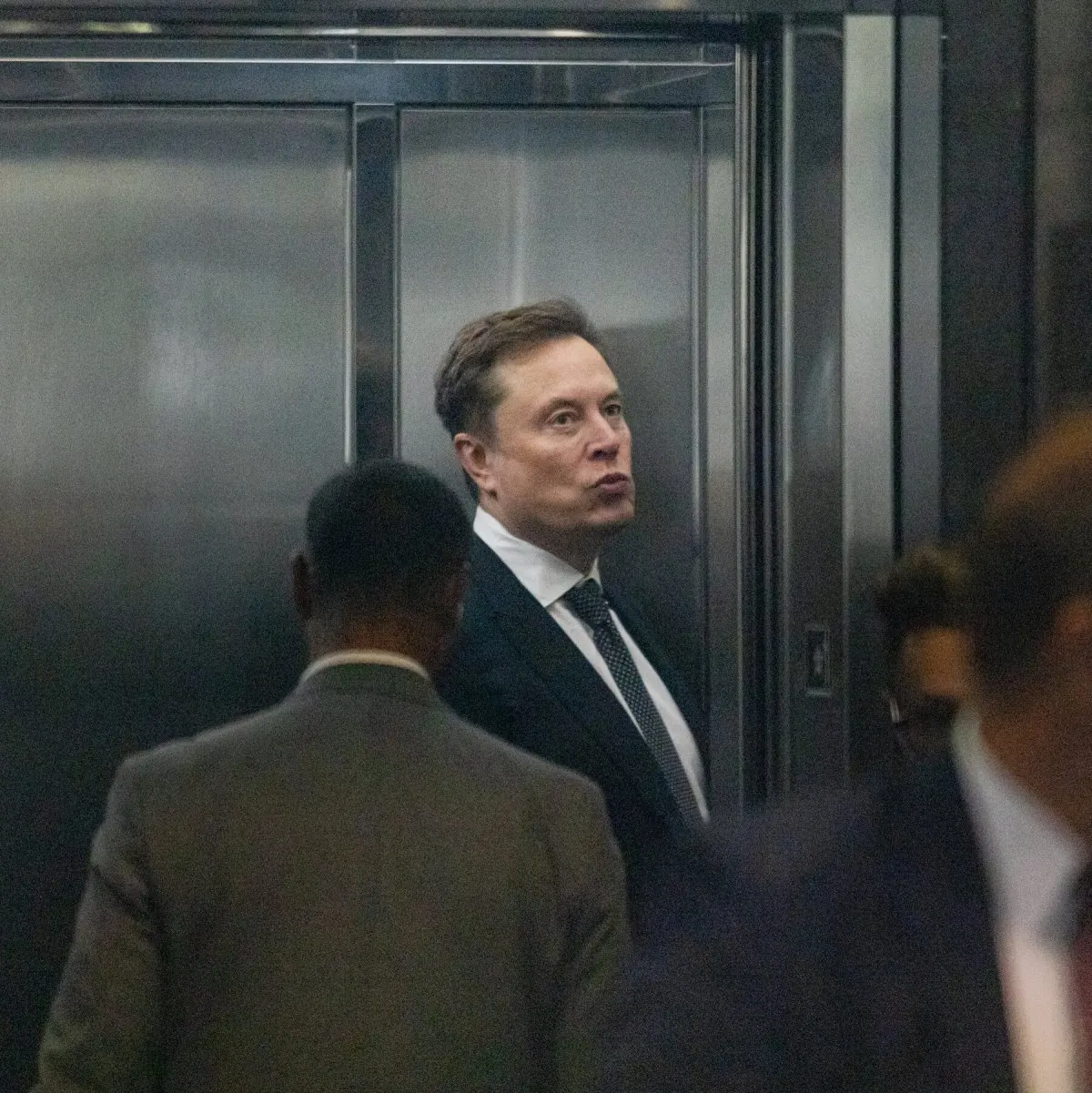 Elon Musk standing outside a courthouse after his lawsuit against OpenAI and Sam Altman was dismissed.
