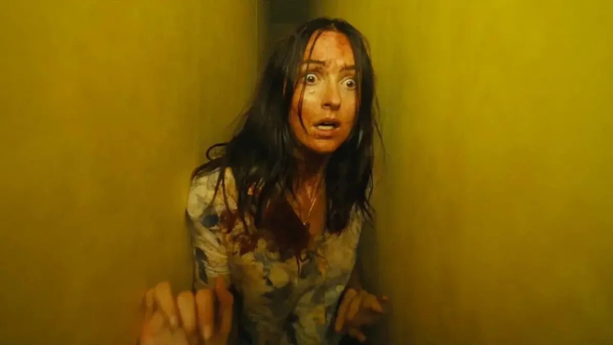 The film features a dimly lit hallway with yellow wallpaper and fluorescent lighting.