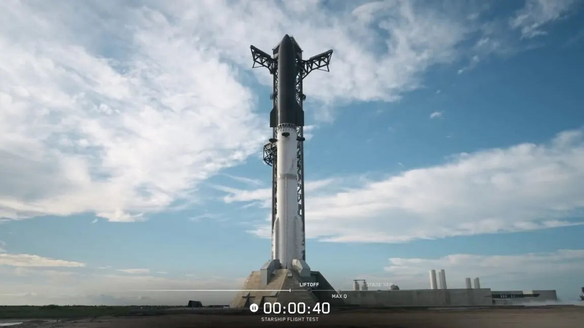 The Starship V3 rocket stands on the launch pad near the launch tower during a scrubbed launch attempt.