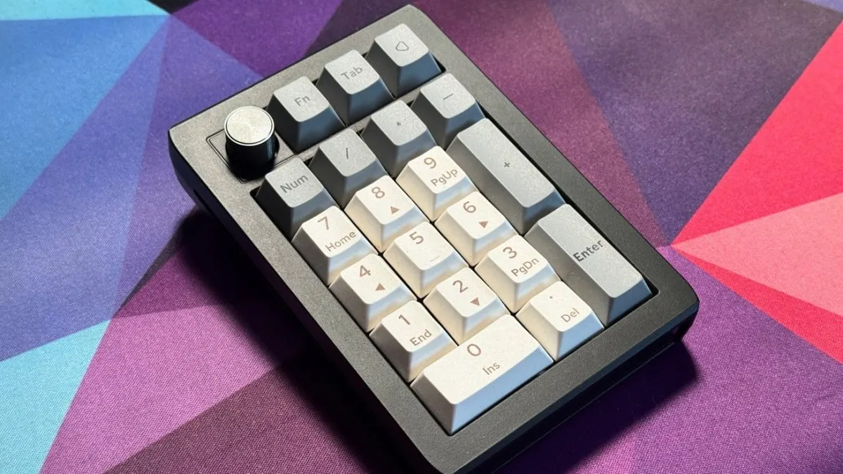A spare keyboard sits beside a Mac computer while the macOS settings window displays macro configuration options.
