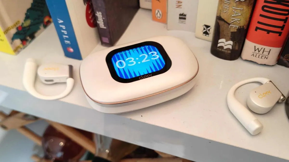 Wireless earbuds inside a charging case with a touchscreen display.