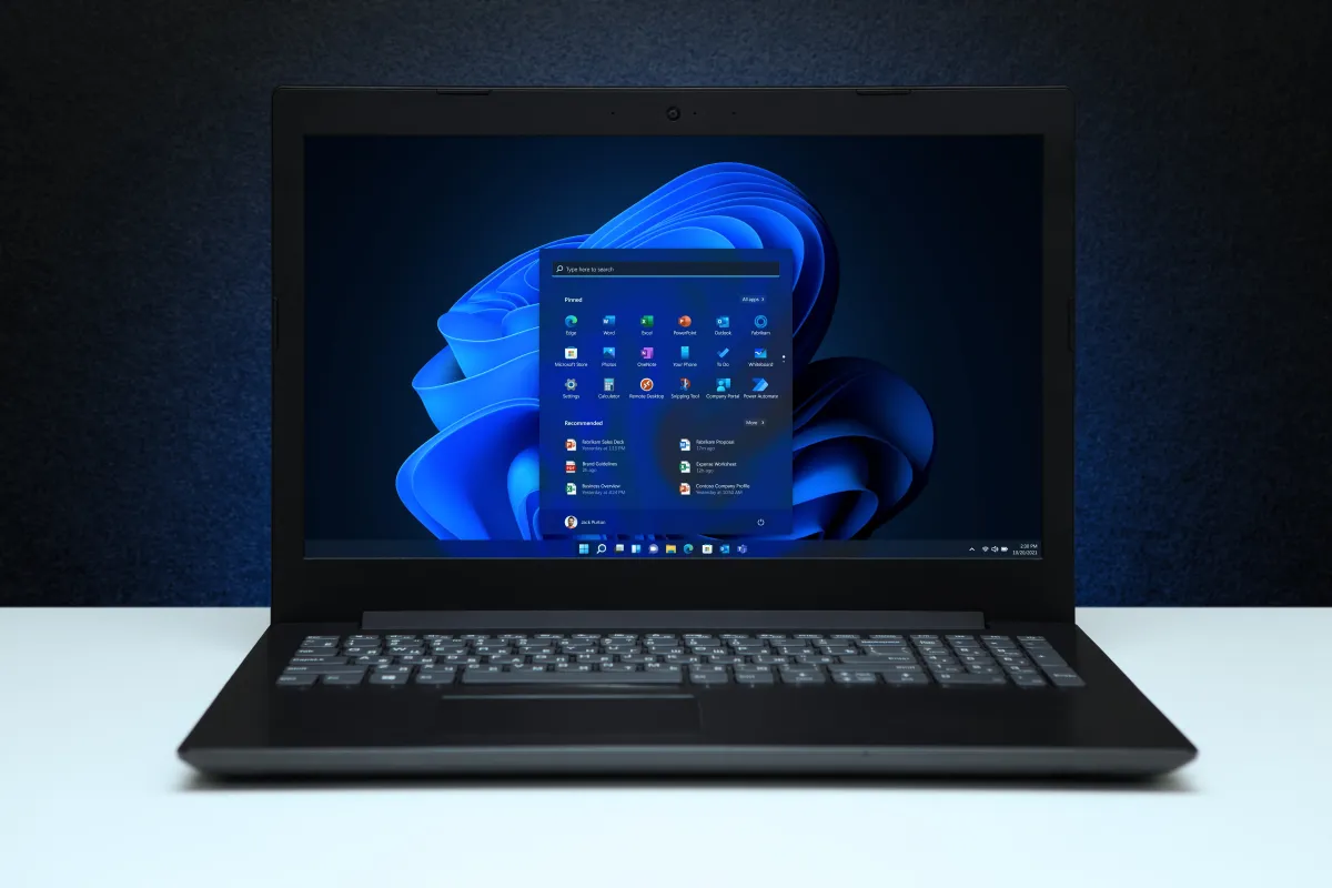 Two Bluetooth headphones connect to a Windows 11 computer for simultaneous shared audio playback.