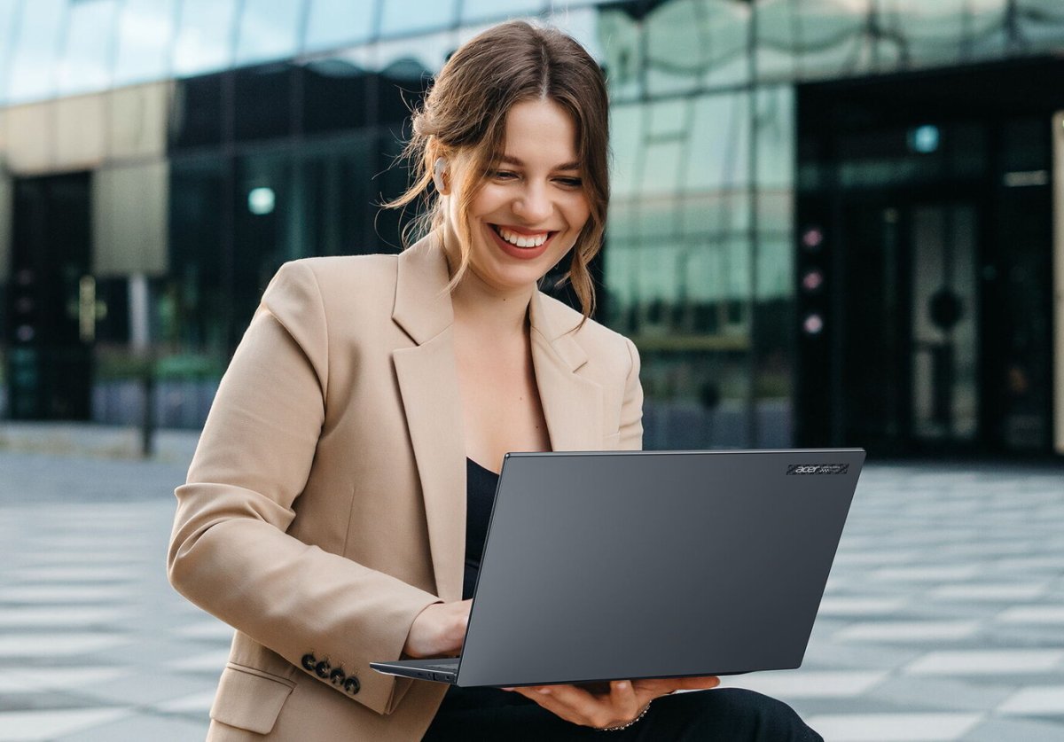 The Acer TravelMate P6 14 AI laptop is shown open on a desk.