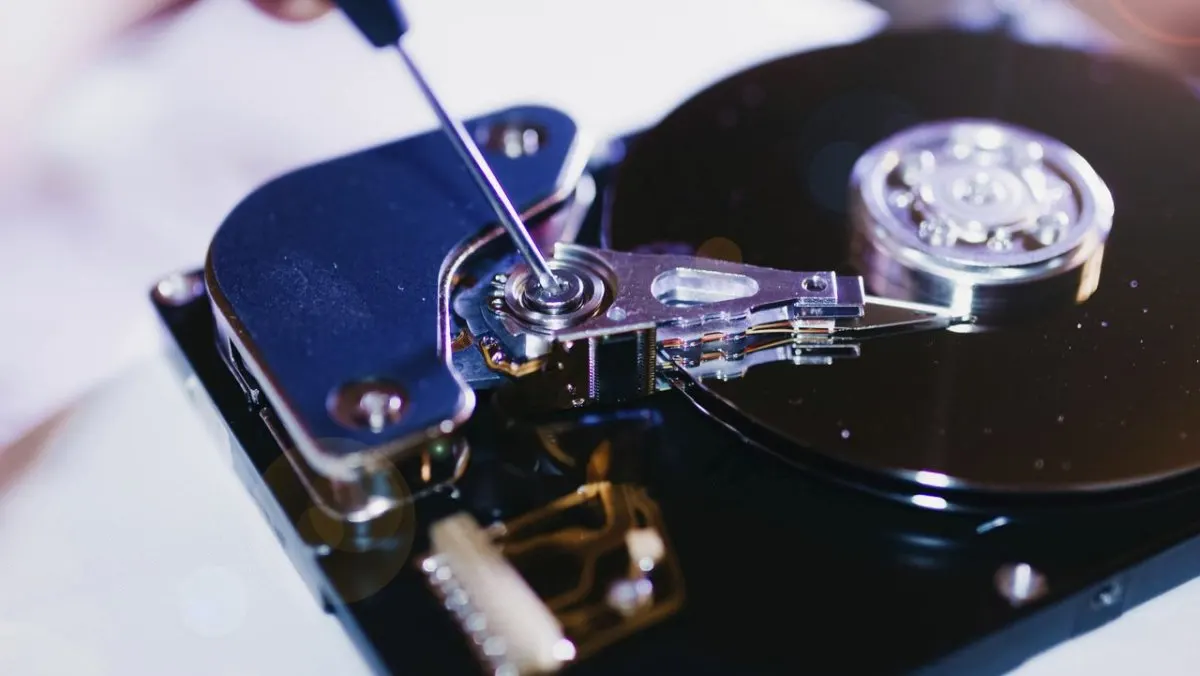 The image shows hard drive suspension components linked to a class action price fixing lawsuit.