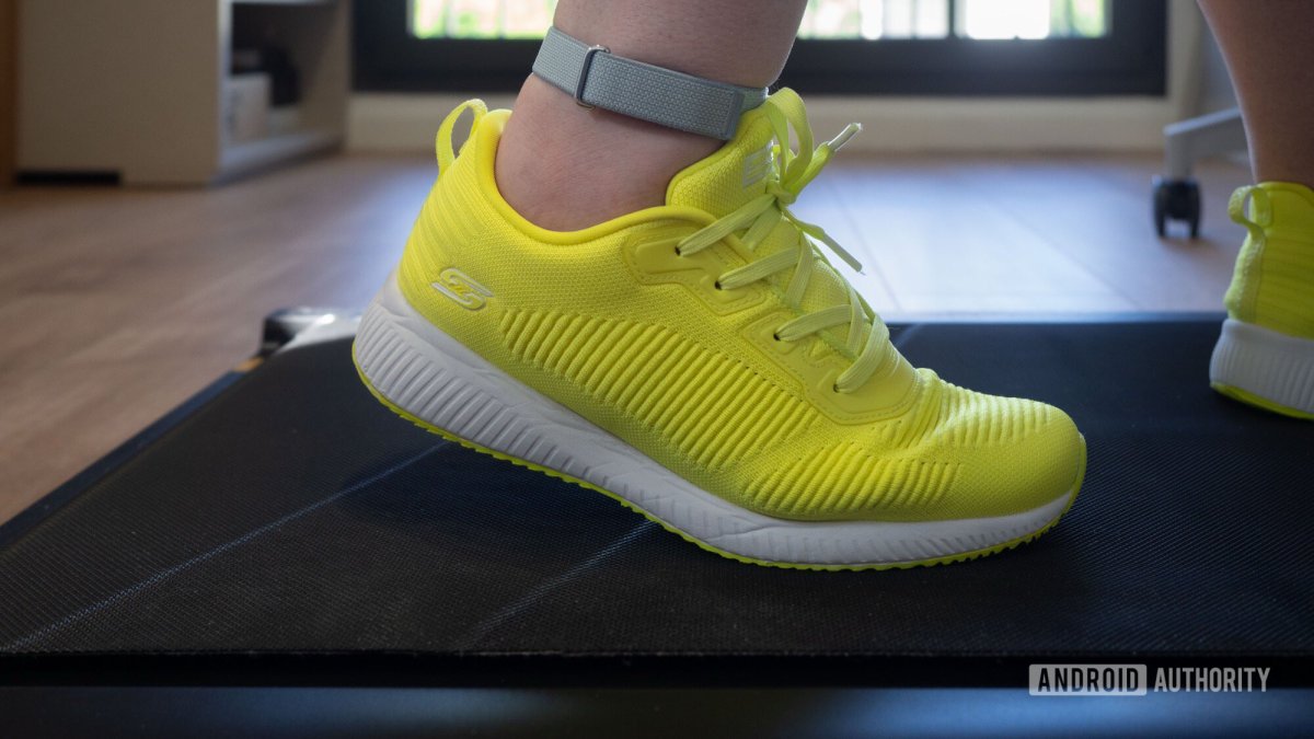 Fitbit Air tracker secured to an ankle strap during treadmill walking to demonstrate improved step counting accuracy.