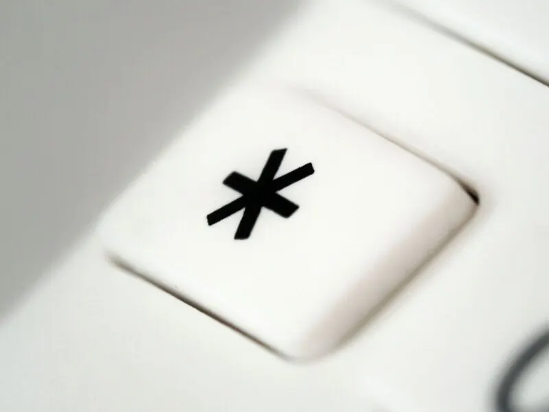 A vintage mainframe terminal displays an asterisk symbol representing a wildcard error.