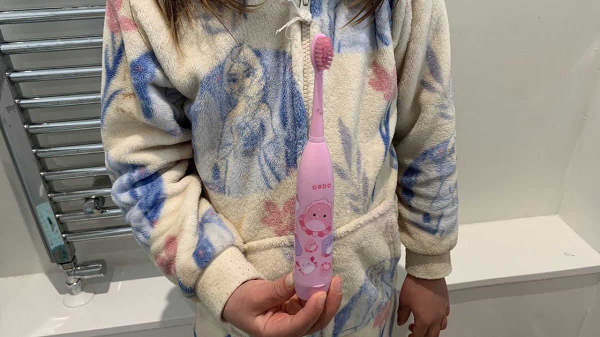 Ordo Sonic Kids battery toothbrush with a standard brush head attached, displayed on a neutral surface.