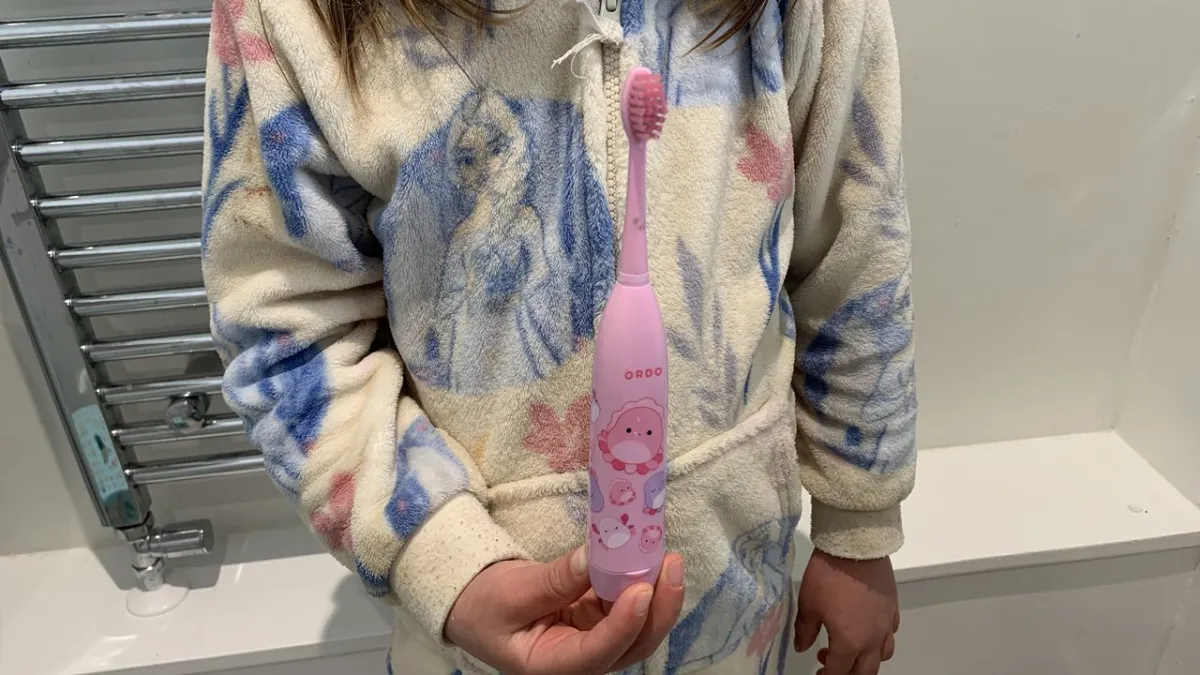 Ordo Sonic Kids battery toothbrush with a standard brush head attached, displayed on a neutral surface.