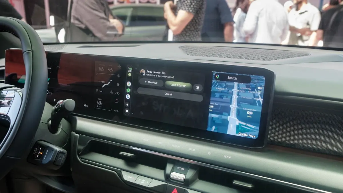 The updated Android Auto interface displays three-dimensional navigation and Gemini voice controls on a car screen.