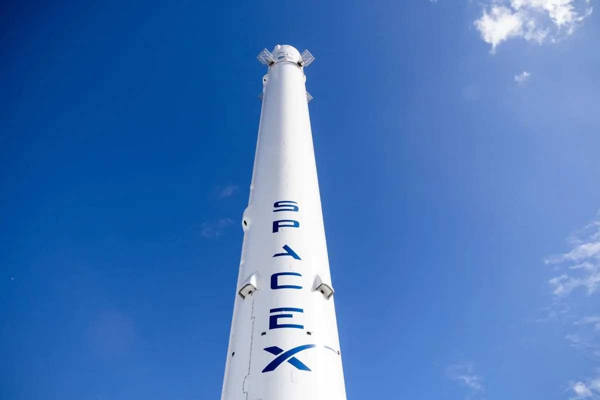 Elon Musk at a corporate presentation with SpaceX branding visible