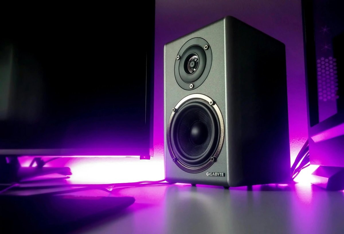 A pair of compact computer speakers resting on a desk surface.
