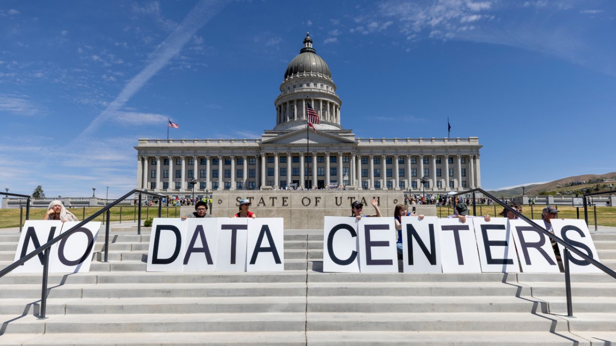 Demonstrators protesting near a large artificial intelligence data center