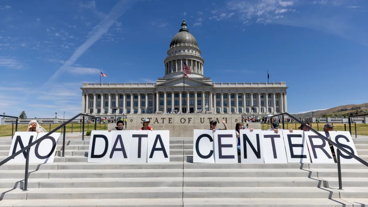 Demonstrators protesting near a large artificial intelligence data center