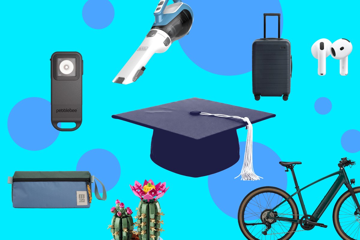 A selection of graduation gifts including a watch, diploma cover, and cap and gown laid out on a surface.