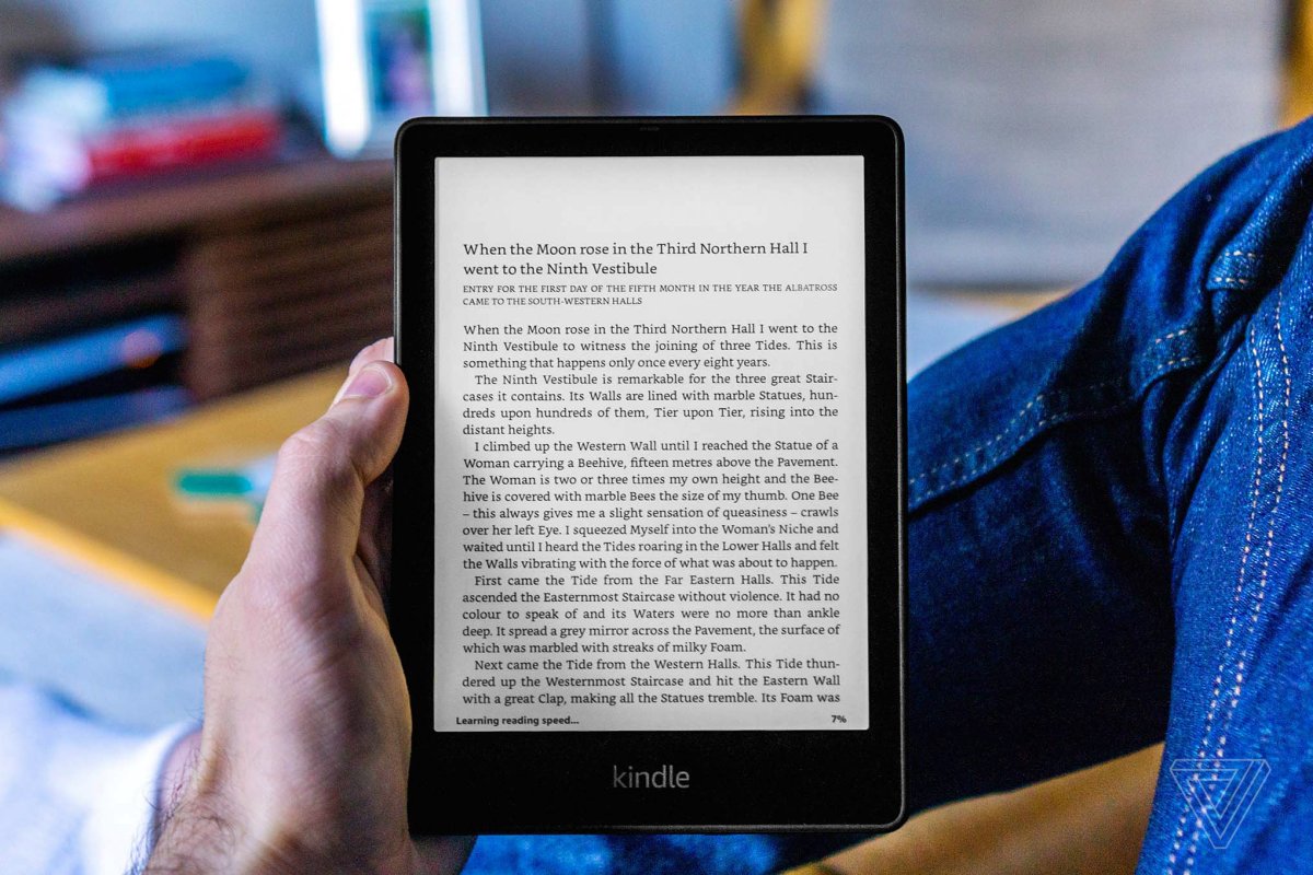 A close-up of the 2021 Kindle Paperwhite e-reader displaying a book page on its 6.8-inch screen.