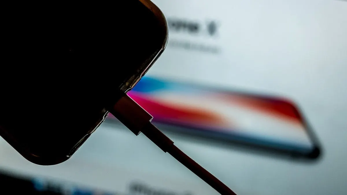 A smartphone connected to a charger displays battery health and optimization settings.