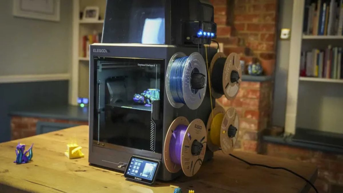 Three 3D printers from Elegoo, Bambu Lab, and Creality are displayed side by side for Memorial Day discount comparison.