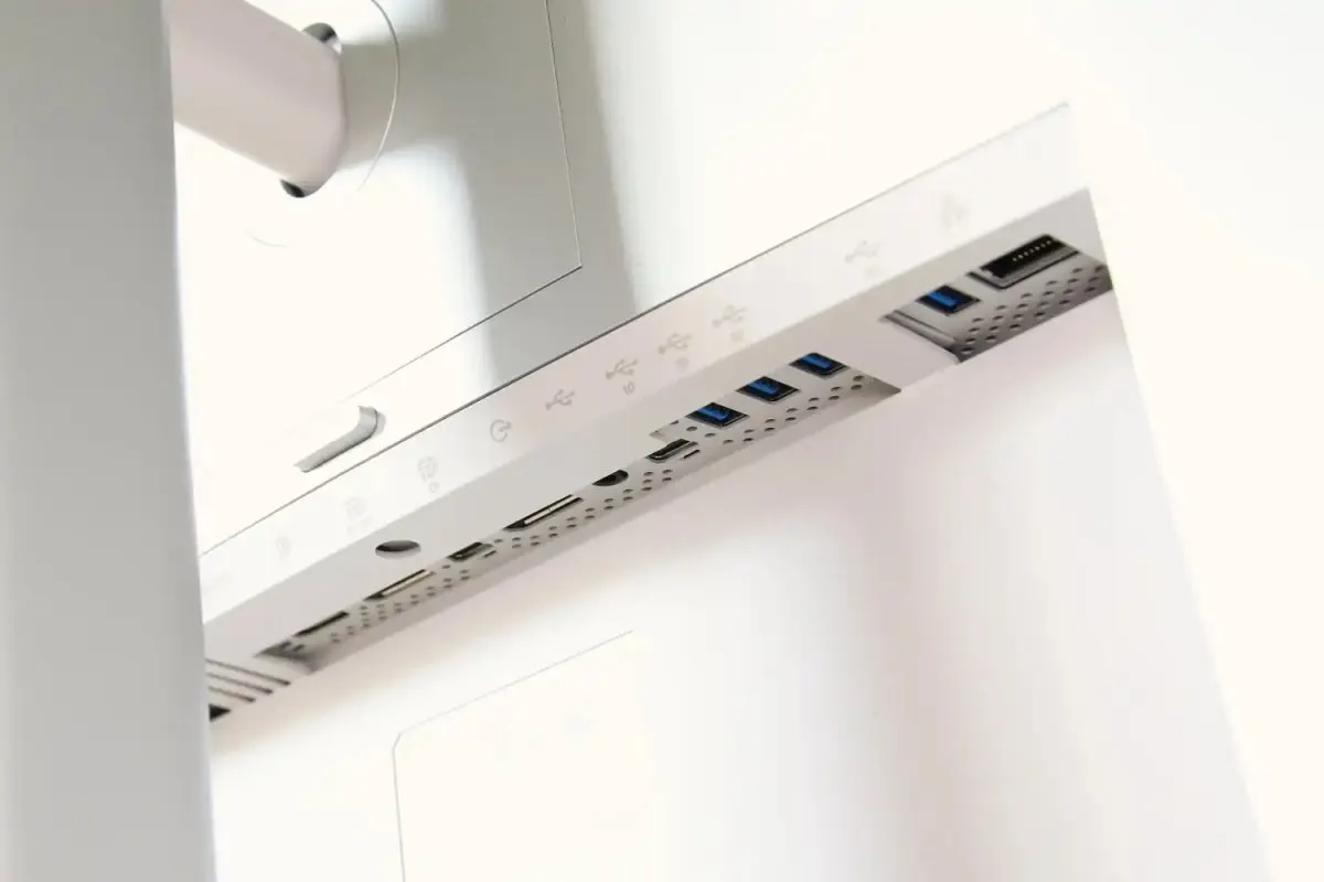A USB-C monitor displays a desktop interface alongside connected peripherals and power delivery indicators.