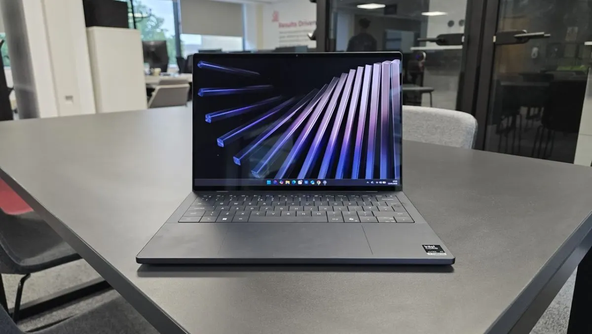 Dell XPS 14 laptop shown open with its OLED display and keyboard visible.