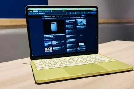 Apple MacBook Neo laptop on a desk next to a 2026 price comparison chart.