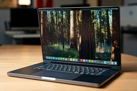 A laptop OLED display panel undergoes manufacturing testing for upcoming MacBook Pro models.