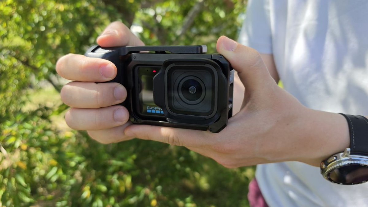 A GoPro Mission 1 Pro camera rests on a surface with its new grip attached.