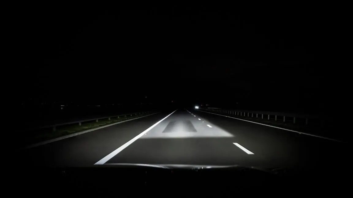 The adaptive driving beam headlight masks light around other vehicles while maintaining forward illumination.