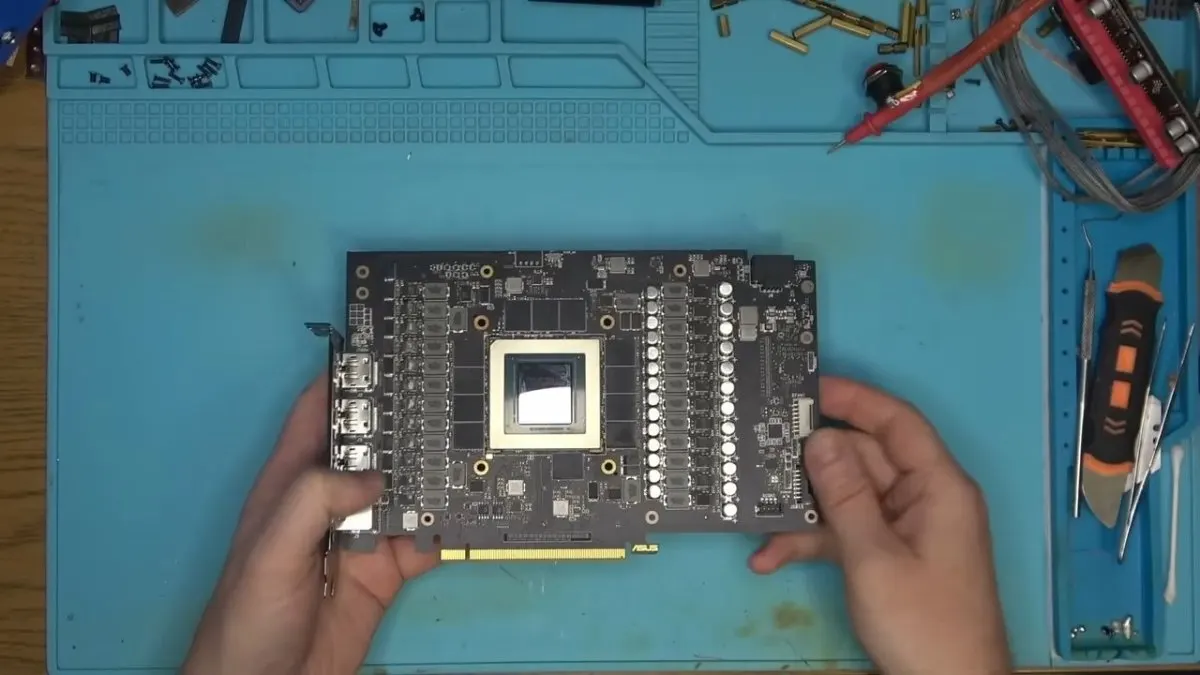A detailed view of an Asus ROG Strix RTX 4090 graphics card resting on a technician workbench.