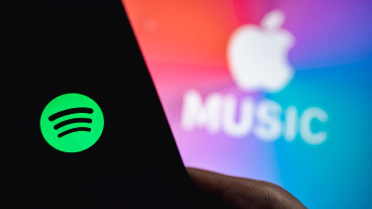Apple devices display the music streaming interface to demonstrate cross-platform playback limitations.