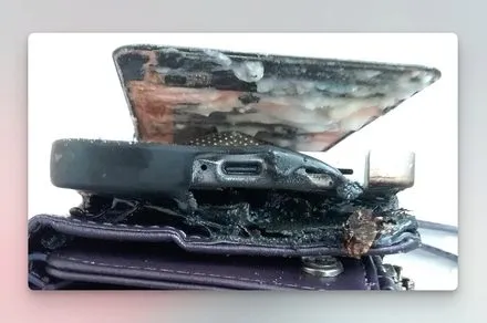 A Samsung Galaxy S25 smartphone shows battery damage and smoke following an overnight charging failure.