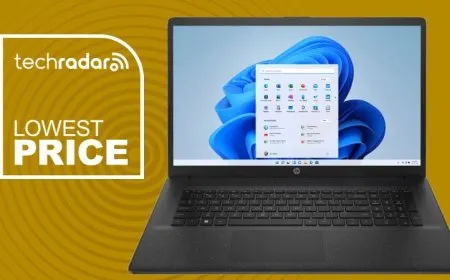 A budget laptop rests next to an AMD Ryzen 5 7430U processor chip and pricing charts.