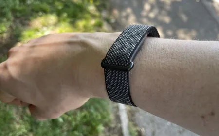 The Google Fitbit Air smartwatch displays fitness metrics and weather data on its screen.