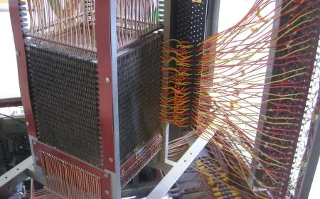 Intersecting copper wires threading through tiny ferrite rings in Jay Forrester's coincident-current magnetic core memory.