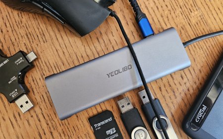 A USB-C hub connects to a laptop with multiple cables attached to its ports for device expansion.