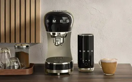 A Smeg ECF12 thermoblock espresso machine is displayed alongside a Mini Milk Frother