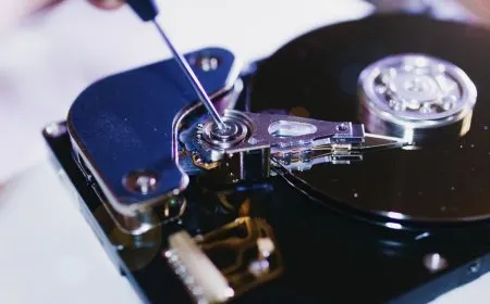 The image shows hard drive suspension components linked to a class action price fixing lawsuit.